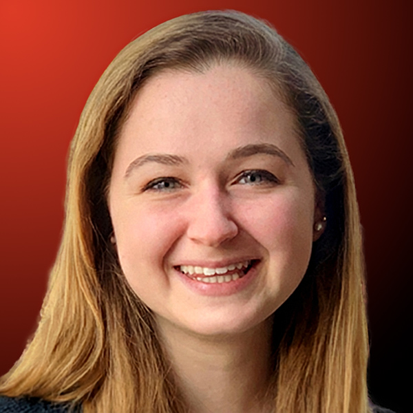 Professional headshot of a smiling woman with long hair against an orange to black gradient background.