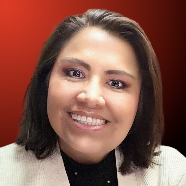 Professional headshot of a smiling woman with dark hair against an orange to black gradient background.